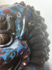 A pair of Chinese cloisonn&eacute; Buddhist lions on a wooden base, 20th C.