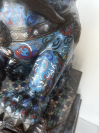 A pair of Chinese cloisonn&eacute; Buddhist lions on a wooden base, 20th C.