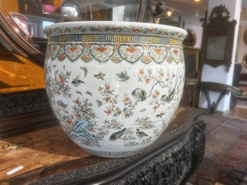 A Chinese famille rose jardini&egrave;re with birds on blossoming branches on an openworked carved wooden stand with marble top, 19th/20th C.