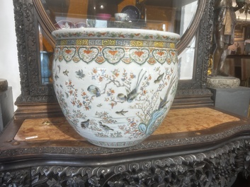 A Chinese famille rose jardini&egrave;re with birds on blossoming branches on an openworked carved wooden stand with marble top, 19th/20th C.