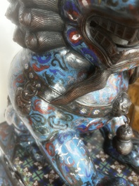 A pair of Chinese cloisonn&eacute; Buddhist lions on a wooden base, 20th C.