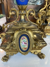 A French gilt bronze three-piece clock garniture crowned with a lady holding a jewelry box, 19th C.
