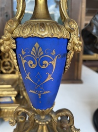 A French gilt bronze three-piece clock garniture crowned with a lady holding a jewelry box, 19th C.