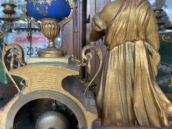 A French gilt bronze three-piece clock garniture crowned with a lady holding a jewelry box, 19th C.