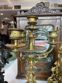 A French gilt bronze three-piece clock garniture crowned with a lady holding a jewelry box, 19th C.