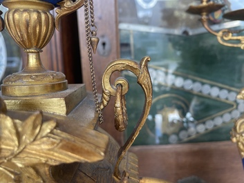 A French gilt bronze three-piece clock garniture crowned with a lady holding a jewelry box, 19th C.
