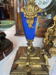 A French gilt bronze three-piece clock garniture crowned with a lady holding a jewelry box, 19th C.