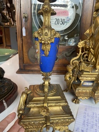 A French gilt bronze three-piece clock garniture crowned with a lady holding a jewelry box, 19th C.