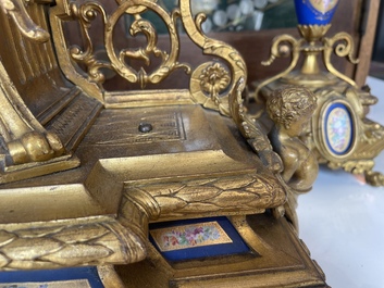 A French gilt bronze three-piece clock garniture crowned with a lady holding a jewelry box, 19th C.