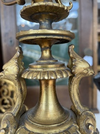 A French gilt bronze three-piece clock garniture crowned with a lady holding a jewelry box, 19th C.