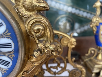 A French gilt bronze three-piece clock garniture crowned with a lady holding a jewelry box, 19th C.