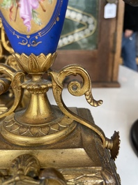 A French gilt bronze three-piece clock garniture crowned with a lady holding a jewelry box, 19th C.