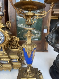A French gilt bronze three-piece clock garniture crowned with a lady holding a jewelry box, 19th C.