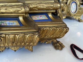 A French gilt bronze three-piece clock garniture crowned with a lady holding a jewelry box, 19th C.