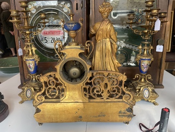 A French gilt bronze three-piece clock garniture crowned with a lady holding a jewelry box, 19th C.