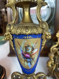 A French gilt bronze three-piece clock garniture crowned with a lady holding a jewelry box, 19th C.