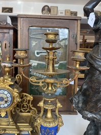 A French gilt bronze three-piece clock garniture crowned with a lady holding a jewelry box, 19th C.