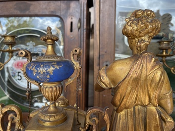 A French gilt bronze three-piece clock garniture crowned with a lady holding a jewelry box, 19th C.