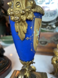A French gilt bronze three-piece clock garniture crowned with a lady holding a jewelry box, 19th C.