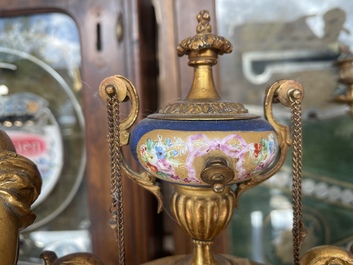 A French gilt bronze three-piece clock garniture crowned with a lady holding a jewelry box, 19th C.