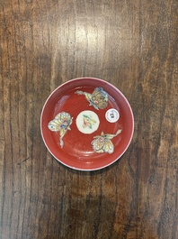 A pair of Chinese famille rose saucers with butterflies on a ruby red ground, 19th/20th C.