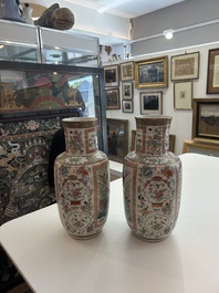 A pair of Chinese Canton famille rose vases with birds and butterflies among blossoming branches and antiques, 19th C.