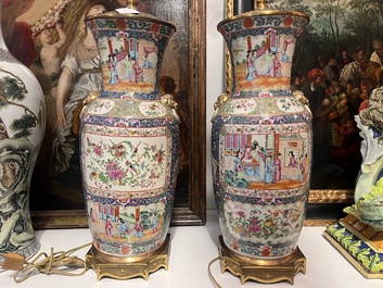 Een paar Chinese Kanton famille rose vazen met blauwe fondkleur, paleissc&egrave;nes en floraal decor omgevormd tot lampen, 19de eeuw
