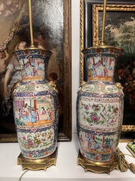 Een paar Chinese Kanton famille rose vazen met blauwe fondkleur, paleissc&egrave;nes en floraal decor omgevormd tot lampen, 19de eeuw