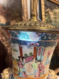 Een paar Chinese Kanton famille rose vazen met blauwe fondkleur, paleissc&egrave;nes en floraal decor omgevormd tot lampen, 19de eeuw