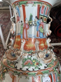 Een paar Chinese Kanton famille rose vazen met paleissc&egrave;nes en floraal decor, 19de eeuw
