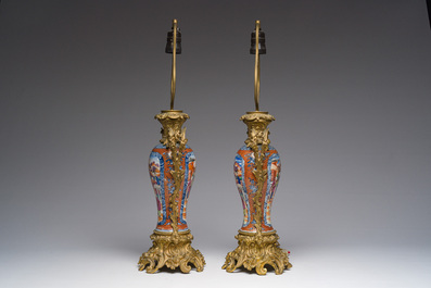 Een paar Chinese famille rose vazen met mandarijns decor met verguld bronzen monturen omgevormd tot lampen, Qianlong