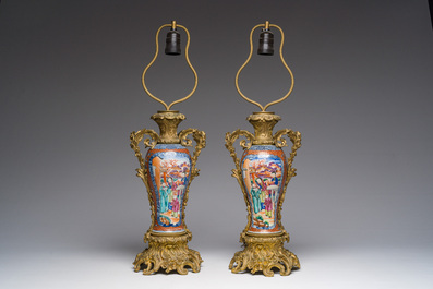 Een paar Chinese famille rose vazen met mandarijns decor met verguld bronzen monturen omgevormd tot lampen, Qianlong