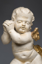 A Flemish patinated and gilt wooden angel mounted on a pedestal, 18th C.