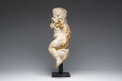A Flemish patinated and gilt wooden angel mounted on a pedestal, 18th C.