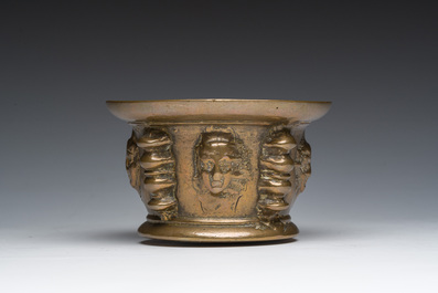 Een Franse bronzen vijzel met mascarons en stamper, vermoedelijk Le Puy-en-Velay, 16de/17de eeuw