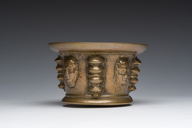 Een Franse bronzen vijzel met mascarons en stamper, vermoedelijk Le Puy-en-Velay, 16de/17de eeuw