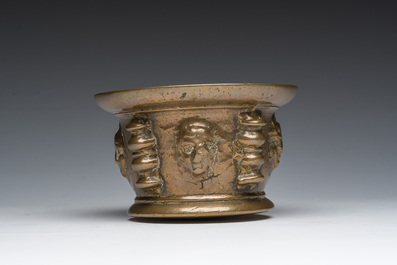 Een Franse bronzen vijzel met mascarons en stamper, vermoedelijk Le Puy-en-Velay, 16de/17de eeuw