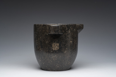 Een Franse zwartmarmeren vijzel met een latere houten stamper, 18de/19de eeuw