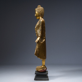 Een Thaise ingelegd verguld houten figuur van een staande Boeddha, 20ste eeuw