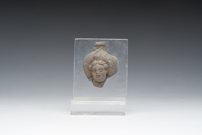 Een Romeins terracotta fragment van een fles met een hoofd in reli&euml;f, vermoedelijk 1ste/3de eeuw