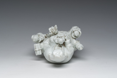 Een Chinese Dehua blanc de Chine figuur van Guanyin met dienaars, 19de eeuw