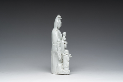 Een Chinese Dehua blanc de Chine figuur van Guanyin met dienaars, 19de eeuw