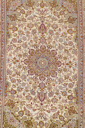 A Persian Isfahan rug and a Turkmen rug with floral design, wool, cotton and silk, 20th C.