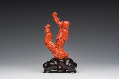 A Chinese red coral group with the 'Star God' Shou Xing and a lady, 19th/20th C.