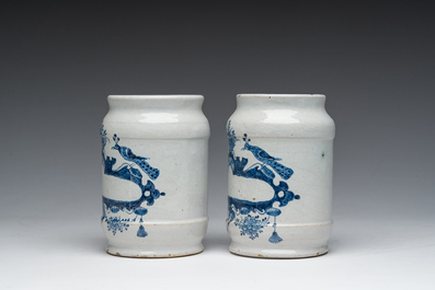 Three Dutch Delft blue and white dishes with a bird and floral design and two pharmacy jars, 18th C.