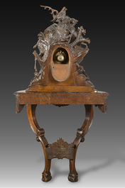A large carved wooden 'Black Forest' clock with a deer hunt on a console tabel with floral design, 19th/20th C.
