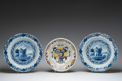 A pair of Dutch Delft blue and white dishes with a building in a landscape and a polychrome plate with a fruit basket, 18th/19th c.