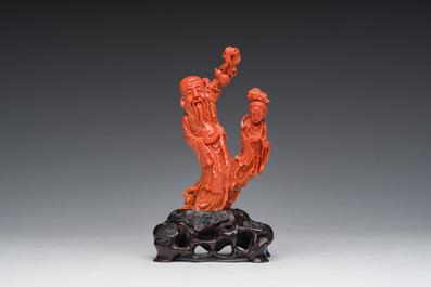 A Chinese red coral group with the 'Star God' Shou Xing and a lady, 19th/20th C.