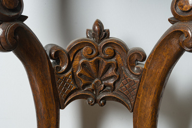 A large carved wooden 'Black Forest' clock with a deer hunt on a console tabel with floral design, 19th/20th C.