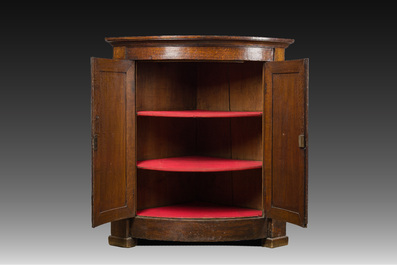 A Flemish Empire style carved oak two-door corner cupboard, 19th C.